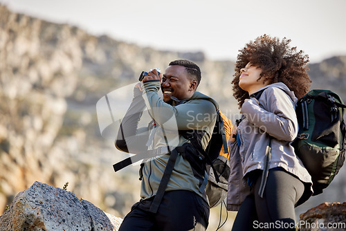 Image of Hiking, camera and photographer with couple in mountains for journey, climbing and travel. Relax, trekking and adventure with black man and woman hiker in nature for exercise, picture and motivation