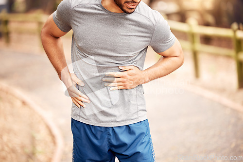 Image of Stomach pain, fitness hands and man outdoor after running, workout and exercise. Sports, abdomen ache and male athlete in nature with injury, emergency hernia or problem, sick or training accident.