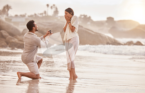 Image of Couple at beach, surprise proposal and engagement with love and commitment with ocean and people outdoor. Travel, seaside and man propose marriage to woman, wow reaction and happiness with care