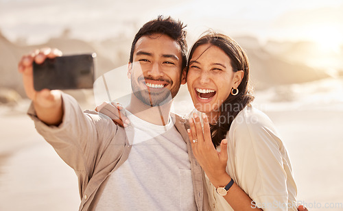 Image of Engagement, selfie and couple with love, beach and bonding with happiness, celebration and romance. Commitment, man and woman on a seaside holiday, social media and proposal with a memory and travel