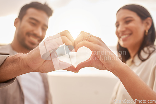 Image of Heart hands, happy and a couple at the beach for love, date and travel together in Bali. Smile, emoji and a man and woman with a shape and hand gesture for romance, ocean holiday and bonding