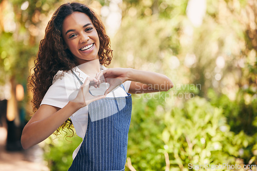 Image of Heart hands, portrait and a woman with love at a nursery, garden job or sustainable small business. Happy, care and a florist with a shape gesture or emoji for nature, plants and flowers in a park