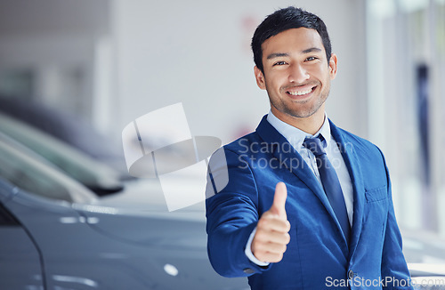 Image of Portrait, thumbs up and car salesman smile at showroom for ok, yes and welcome. Face, like hand gesture and dealership manager with emoji for success, agreement or thank you for sales in retail store