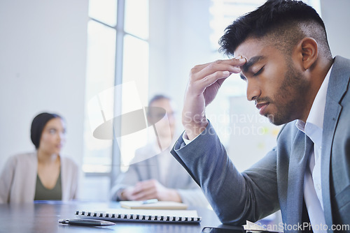 Image of Mental health, businessman with a headache and at a business meeting with colleagues in a boardroom office at their workplace. Stress or depression, anxiety or tired and sad male person at a desk