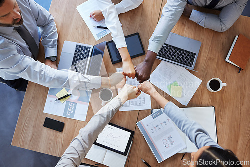 Image of Fist bump, team building or top view of business people in collaboration for group mission in company. Motivation, fists or employees in meeting with goals, teamwork or support in office together