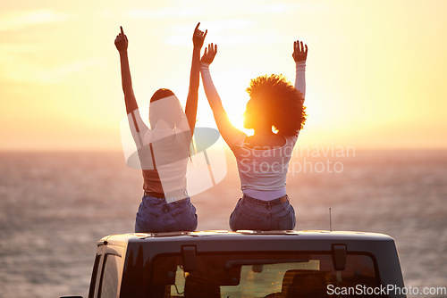 Image of Sunset, women sitting on a car and at the beach with back view for carefree or peace. Freedom or adventure, summer vacation or holiday break and travel with female people at sea happy together