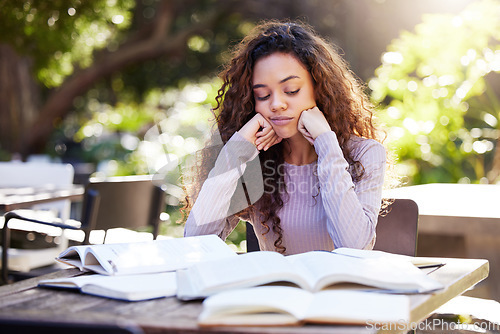 Image of Tired, woman and study books in college, education and learning at outdoor, cafe or working on park table on campus. Girl, studying and university student to work, learn or research from reading