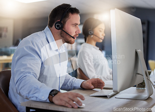 Image of Call center, focus and computer with man in office for communication, customer service or help desk. Telemarketing, sales and advice with male employee for commitment, contact us and hotline