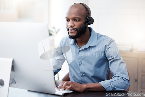 Image of Black man, computer and call center, contact us and communication, concentrate with headset and connect. Male agent with focus, customer service or tech support, help desk employee is reading online