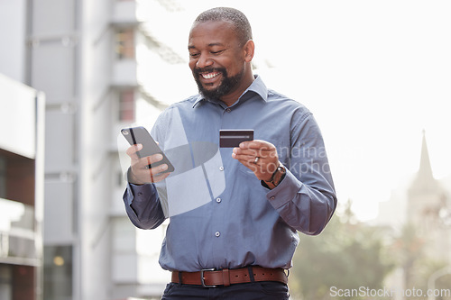 Image of Ecommerce, businessman with smartphone and credit card outside in the city happy. Online shopping, happiness with African male person with a cellphone and his bank information in urban street