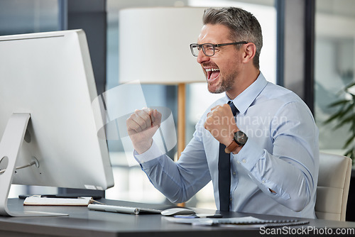 Image of Happy, businessman and fist in celebration for promotion, winning or success by desk at the office. Man employee in joy for win, achievement or bonus on computer in sale, target or prize at workplace