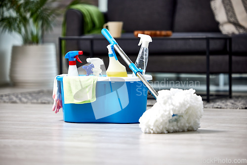 Image of Cleaning, detergent and mop on the floor of a living room in a home for hygiene or service during housework. Product, bacteria and safety with supplies in a bucket ready to clean a house for service