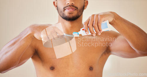 Image of Hands, toothpaste on toothbrush with man and dental, oral health and wellness with brushing teeth. Fresh breath, hygiene and grooming with male person cleaning mouth, self care and morning routine