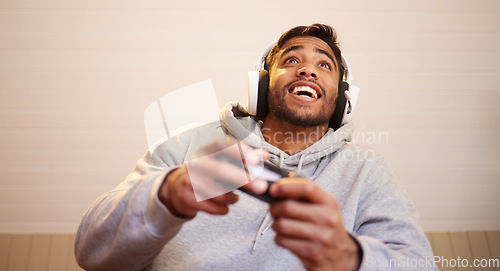 Image of Man play video games, headphones and controller for esports, online streaming and happy at home. Male gamer, smile with entertainment and excited about gaming competition, tech and cyber streamer