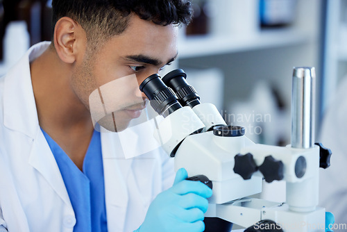 Image of Science, futuristic and a man with microscope in a lab for medical research and analysis. Serious, medicine and a scientist doing a check of chemistry, microbiology or a virus working at a clinic