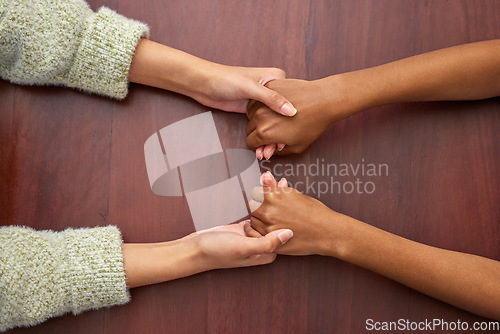 Image of Support, empathy and people holding hands at school for trust, love and respect. Together, sorry and above of friends or students with a helping hand, forgiveness or compassion at a desk in college