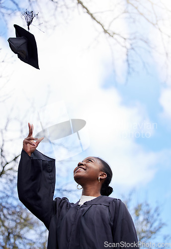 Image of Success, graduation and a black woman throwing a hat for education achievement at a college. Happy, university and an African student or graduate with a cap in the air on a campus to celebrate