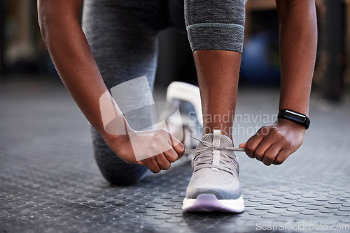 Image of Hands, shoelaces or shoes at gym with woman, fitness or starting workout, wellness or training. Ready, footwear closeup or girl with sneakers for exercise, performance or health motivation in studio