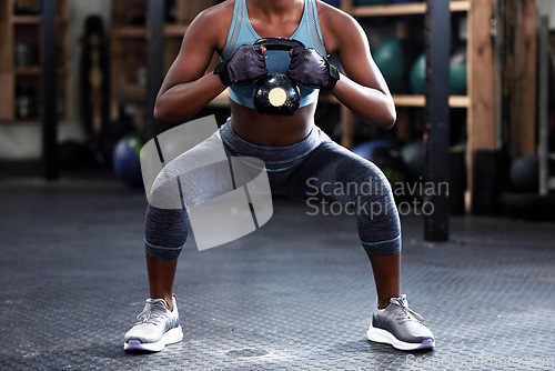 Image of Fitness, kettlebell squat or woman in training, workout or bodybuilding exercise for grip strength or power. Body builder, arms or strong sports athlete with at gym to start lifting heavy weights