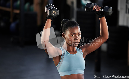 Image of Fitness, dumbbells or strong girl training, exercise or workout for powerful arms or muscles development. Wellness, health or black woman lifting weights or exercising shoulders in gym club studio