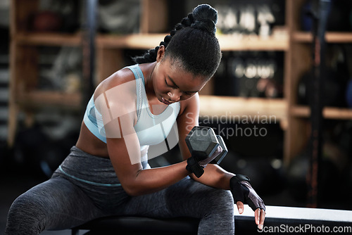 Image of Gym, dumbbell or strong girl training, exercise or workout for powerful arms or muscles for body fitness. Concentration curls, strength or African woman athlete lifting weights or exercising biceps