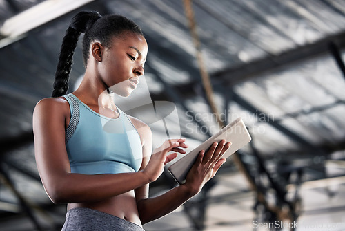 Image of Black woman, typing or personal trainer with a tablet for fitness training, workout or sports exercise. Progress results, digital technology app or gym instructor planning a online coaching schedule