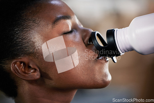 Image of Face, fitness or black woman drinking water in gym after training, workout or exercise to relax or hydrate body. Tired, fitness or tired girl with bottle for healthy liquid hydration on resting break