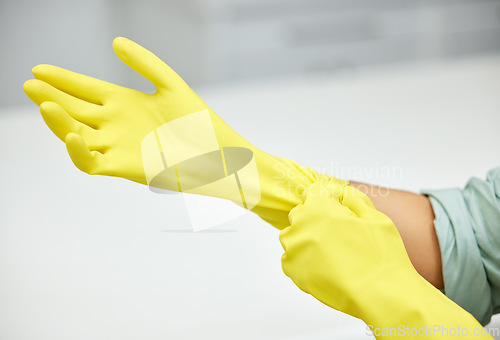 Image of Hands, cleaning and latex gloves for safety or hygiene while indoor for chores or housework as a maid. Bacteria, service and rubber with a cleaner or janitor getting ready for housekeeping duties