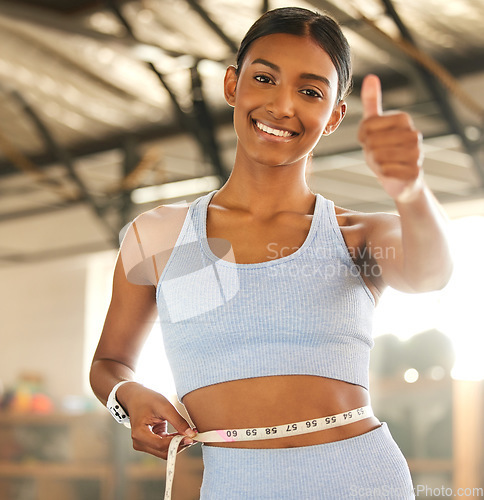 Image of Measure, lose weight or happy woman with thumb up or tape for waist or body goals in fitness studio. Gym, thumbs up or healthy girl measuring her stomach for goal progress, training or motivation