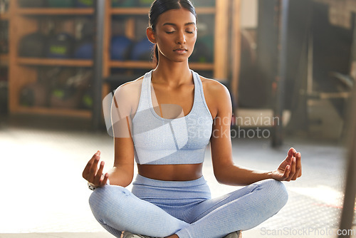 Image of Meditation, yoga and Indian woman in gym for mindfulness, wellness and breathing exercise on floor. Mental health, meditate and female person in lotus pose for mindset, zen and balance in training
