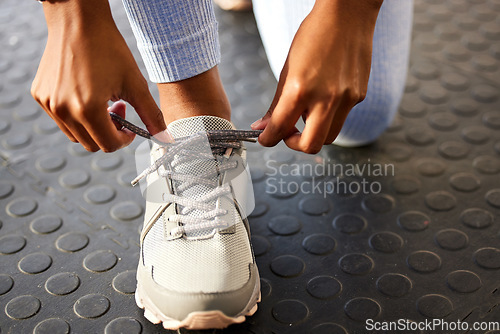 Image of Tie, gym or hands of person with shoes at gym for training, exercise or workout routine in fitness center. Lace, zoom or leg of sports athlete with footwear ready to start exercising on studio floor