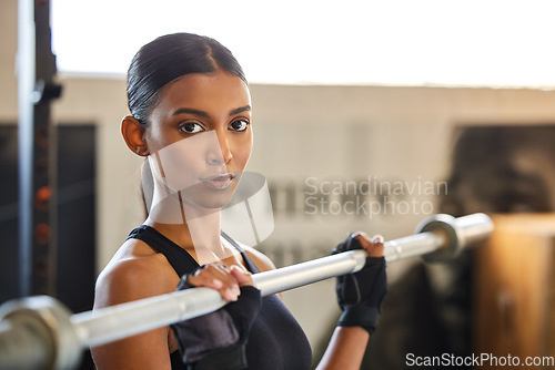 Image of Portrait, Indian woman or bodybuilder with barbell in fitness training, workout or exercise for body building. Strong girl, mindset or healthy athlete weightlifting powerlifting with focus at gym