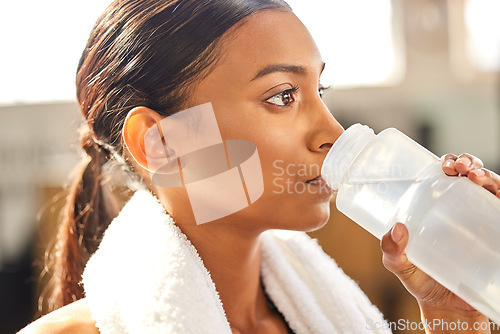 Image of Thirsty, fitness or Indian woman drinking water at gym in training, workout or exercise to hydrate her body. Fatigue, face or tired girl with bottle for healthy liquid hydration on resting break