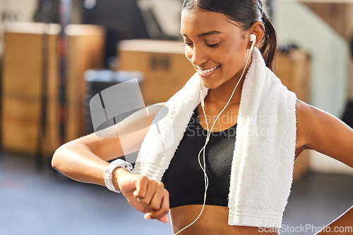 Image of Fitness, timer or happy woman with smartwatch to monitor workout, exercise or training performance. Gym, smile or healthy sports athlete checking smart watch heart rate, pulse or progress results