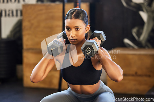 Image of Fitness, squat or woman with dumbbells training, exercise or workout for powerful arms or muscles in gym. Dumbbell squats, bodybuilder or Indian girl athlete lifting weights or exercising biceps