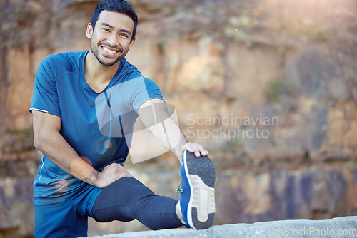 Image of Portrait, sports and stretching with a man runner outdoor in the mountains for a cardio or endurance workout. Exercise, fitness and smile with a young male athlete getting ready for a run in nature