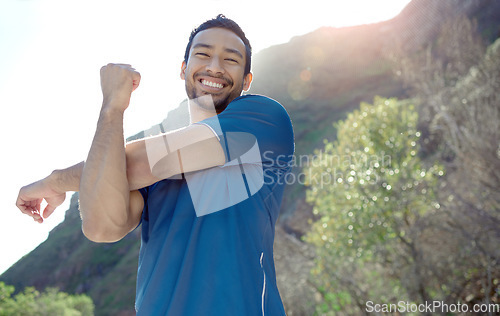 Image of Fitness, portrait and stretching with a man runner outdoor in the mountains for a cardio or endurance workout. Exercise, sports and smile with a young male athlete getting ready for a run in nature