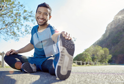 Image of Exercise, portrait and stretching with a man runner outdoor in the mountains for a cardio or endurance workout. Fitness, sports and smile with a young male athlete getting ready for a run in nature