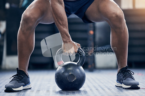 Image of Fitness, floor and kettlebell with a bodybuilder man in the gym for a weightlifting workout routine. Exercise, hand and strong with a male athlete holding a weight in a sports club while training