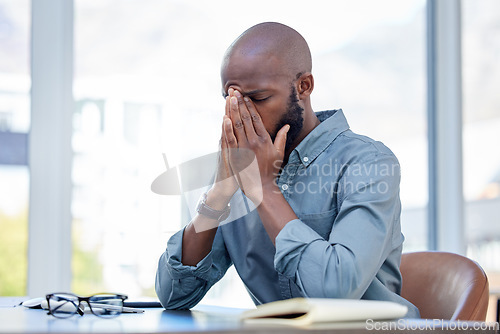 Image of Mental health, businessman with a headache and at his desk of his workplace office. Anxiety or burnout, problem or mistake and African male sitting with stress or sad at his modern workstation