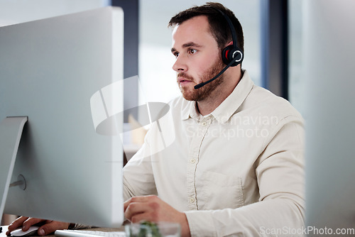 Image of Customer service, man with a headset and computer at desk of his modern office workplace. Telemarketing or online communication, support or crm and male call center agent at his workstation.