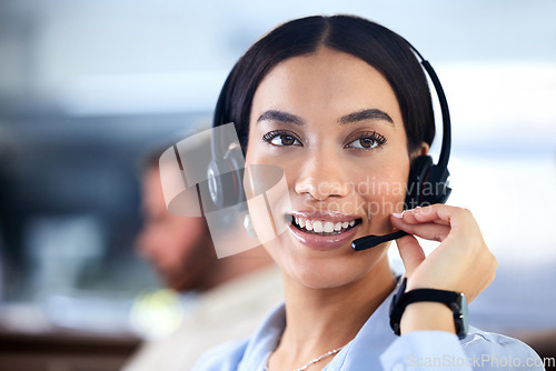 Image of Customer service, woman with a headset and at her desk in a office at her workplace. Consultant or telemarketing, support or online communication and female call center agent smile at workstation