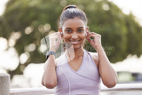 Image of Fitness, portrait of happy woman with earphones in park on workout break listening to music or podcast. Exercise, training and girl with headphones for radio streaming service while running in nature