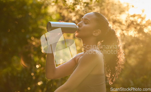 Image of Fitness, woman and drinking water in nature for sustainability, healthy wellness or break from exercise. Calm female person, athlete or runner with drink for hydration after cardio workout in forest