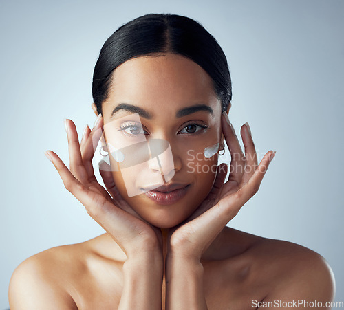 Image of Hands, face cream and woman skincare in studio for dermatology, wellness or anti aging on grey background. Portrait, sunscreen and lady model relax with collagen, mask and lotion, beauty or facial