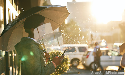 Image of Umbrella, phone and black woman in a city, rain and connection with mobile app, network and chatting. Female person outdoor, weather and girl with a cellphone, contact and communication with cover