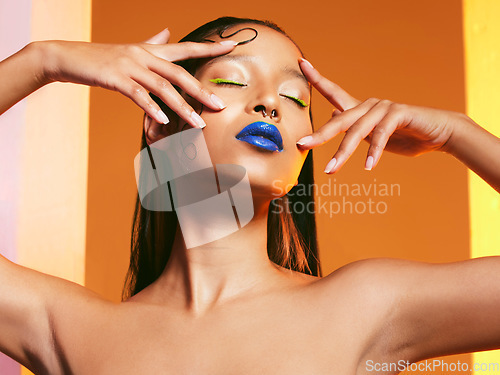 Image of Blue lipstick, makeup and face of woman in studio for cosmetics, eye shadow and beauty salon. Creative aesthetic, cosmetology and female person pose with hands for glamour, luxury style and glow