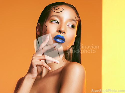 Image of Cosmetics, blue lipstick and face of woman in studio for makeup, eye shadow and beauty salon. Creative aesthetic, cosmetology and female person with neon color for glamour, luxury style and glow