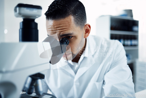 Image of Research, microscope and man scientist in a laboratory for experiment, analysis and innovation. Science, development and male health expert checking results, cancer or bacteria or sample in a lab