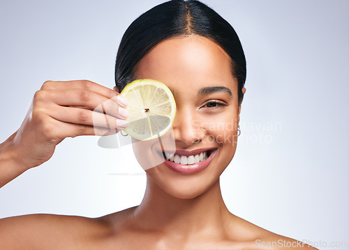 Image of Woman, skincare and lemon in studio portrait with smile, happiness or natural glow on skin by white background. Girl, model and happy for fruit, cosmetics or youth with wellness, nutrition and shine